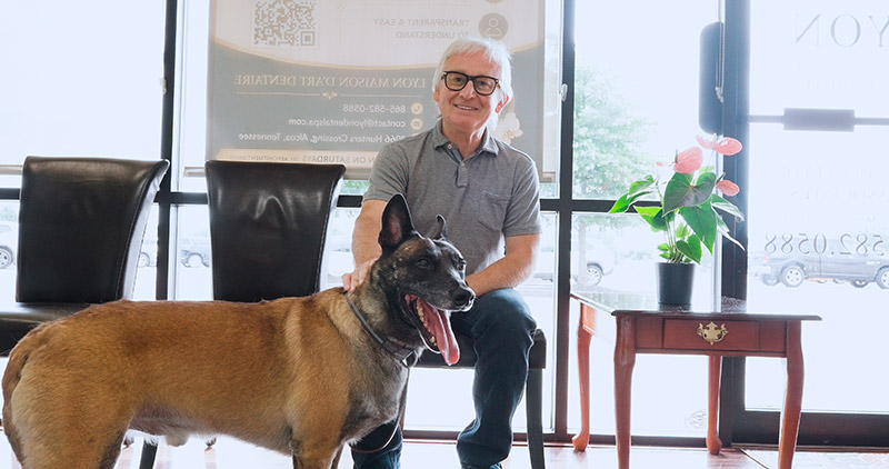 male patient sitting with therapy dog in waiting room